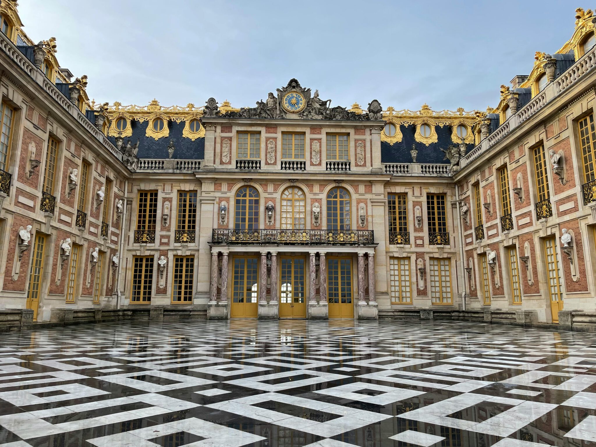 Explore the Baroque architecture of the Palace of Versailles courtyard with intricate facade details.